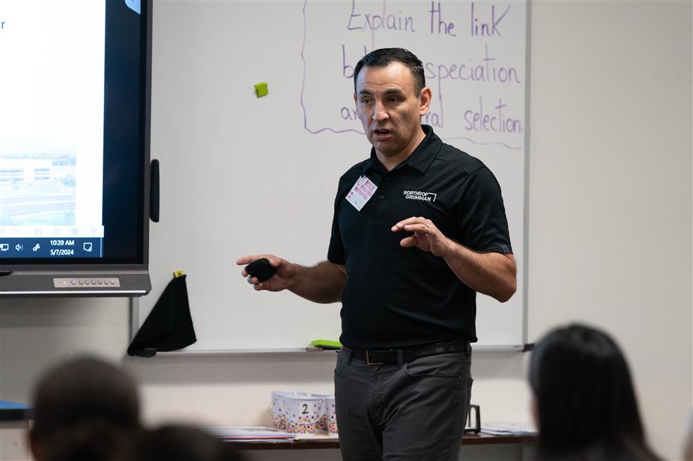 A guest speaker from Northrop Grumman talks with a class at Bogle Junior High School